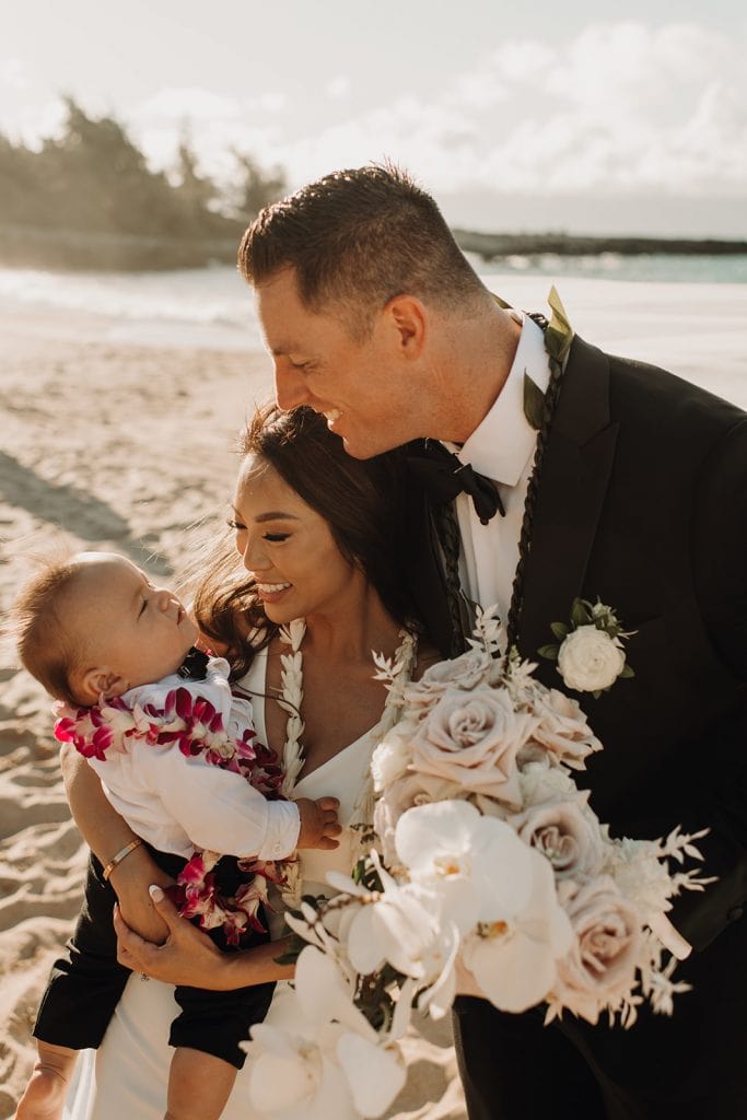 couple holding baby after ceremony