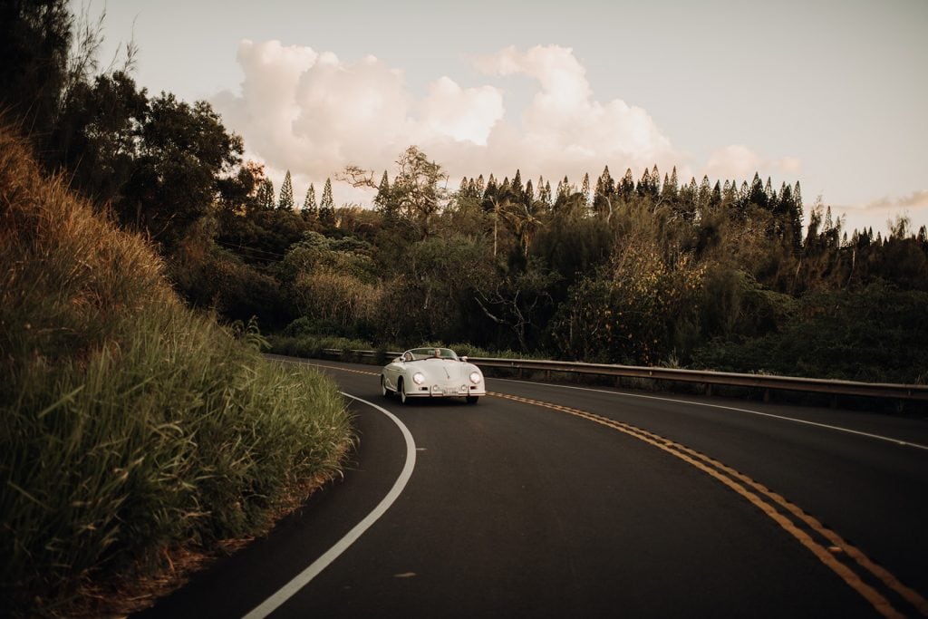 vintage Porsche driving down winding road in hawaii