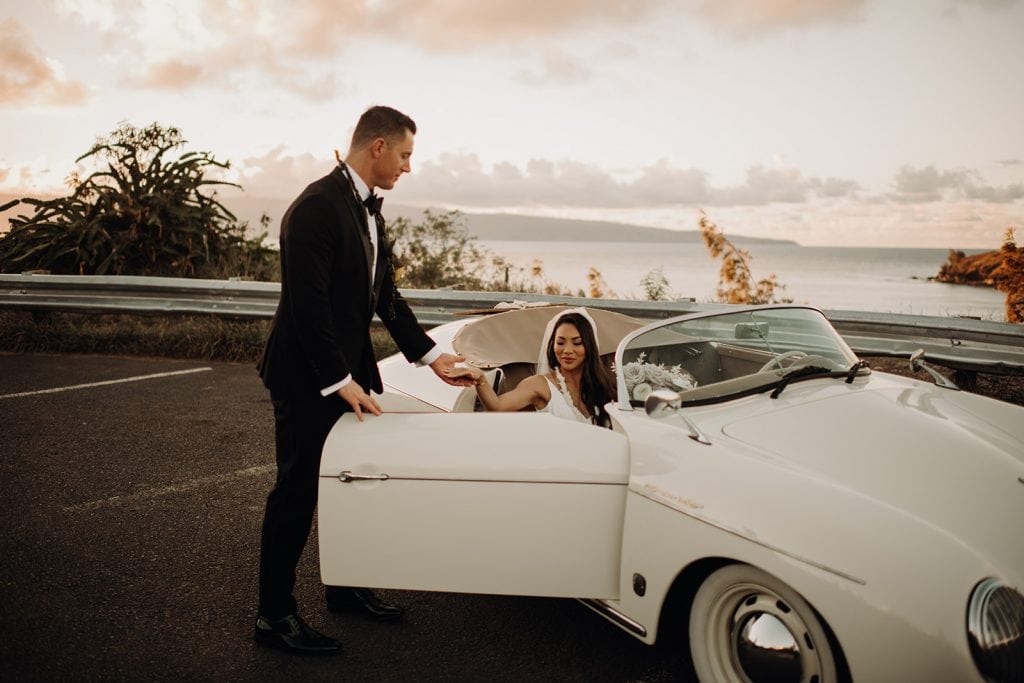 groom helping bride out of porsche