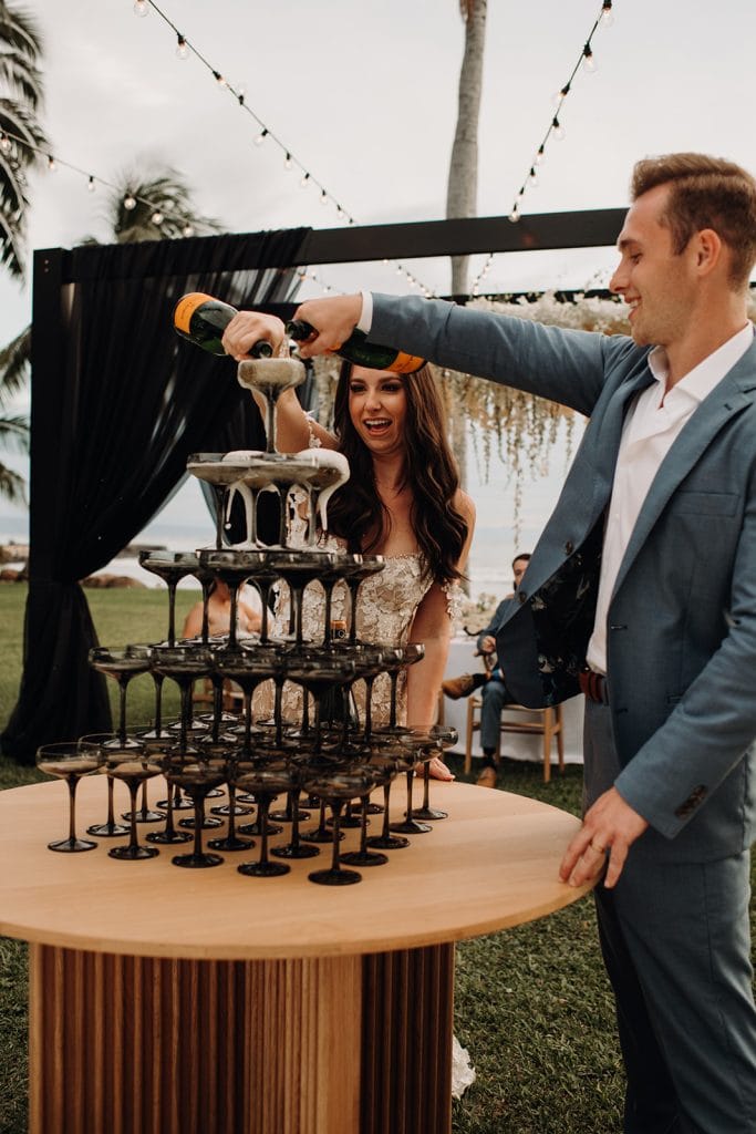 Anna + Garrett pouring champagne in tower