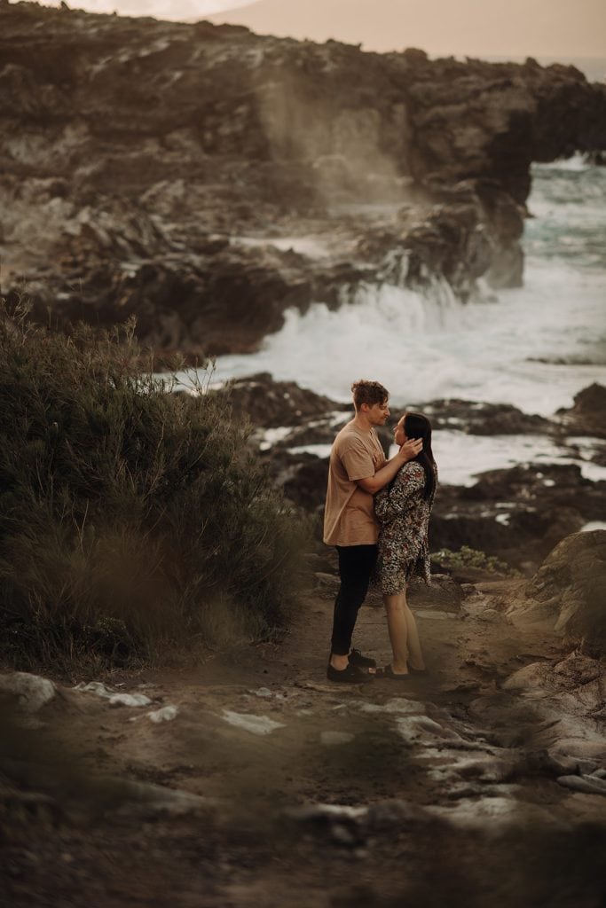 couple standing on rocks facing each other