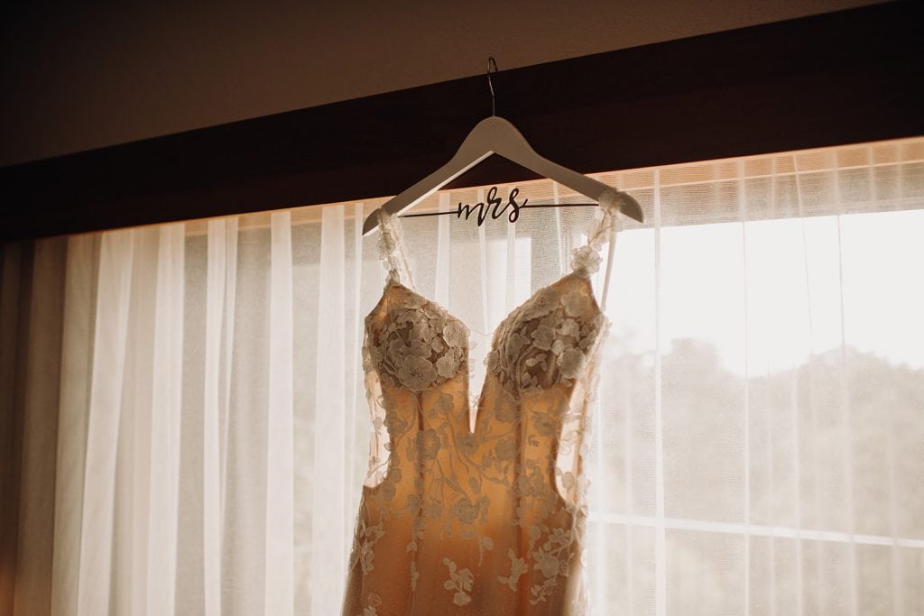 bride's wedding dress hanging in the window