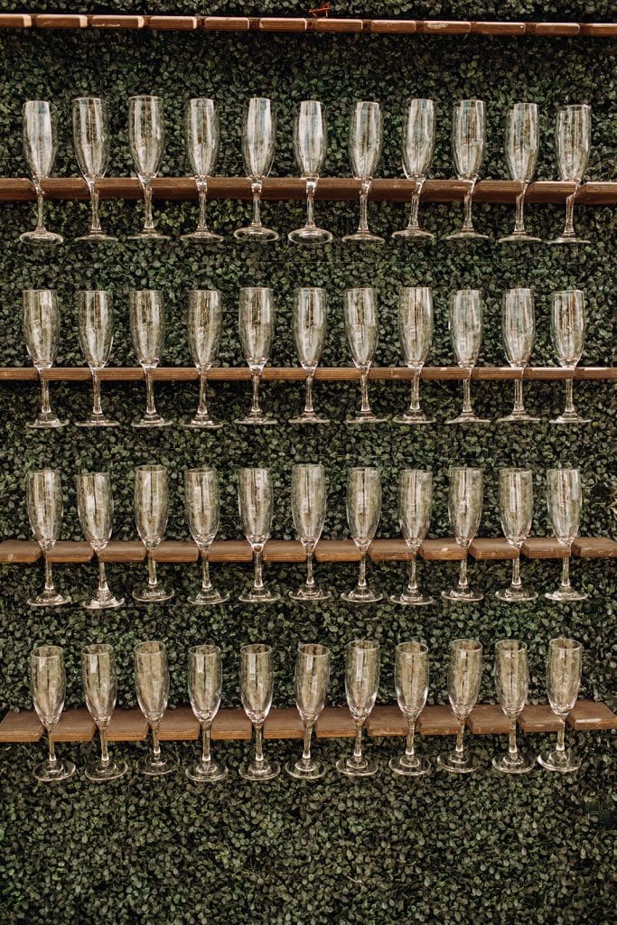 wall of champagne glasses on greenery