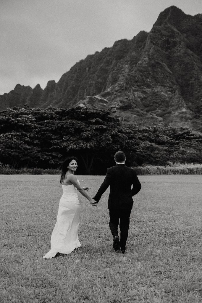 Candid shot of a couple exploring the scenic beauty of Kualoa Regional Park, creating timeless memories together.