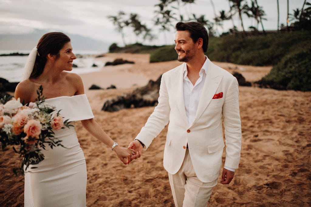 Bride and groom's romantic stroll along the shoreline, capturing the essence of their love story in Maui.