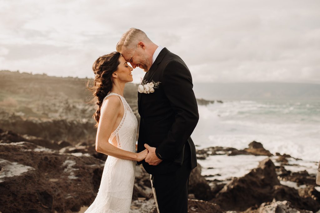 The couple gazes into each other's eyes, surrounded by the natural beauty of Ironwoods Beach in Kapalua for their elopement photography.