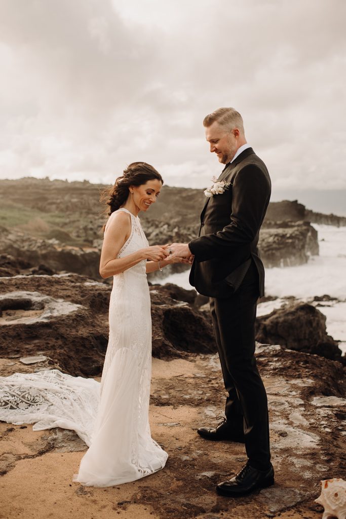 A close-up shot of the couple exchanging vows, framed by the stunning ocean view behind them.