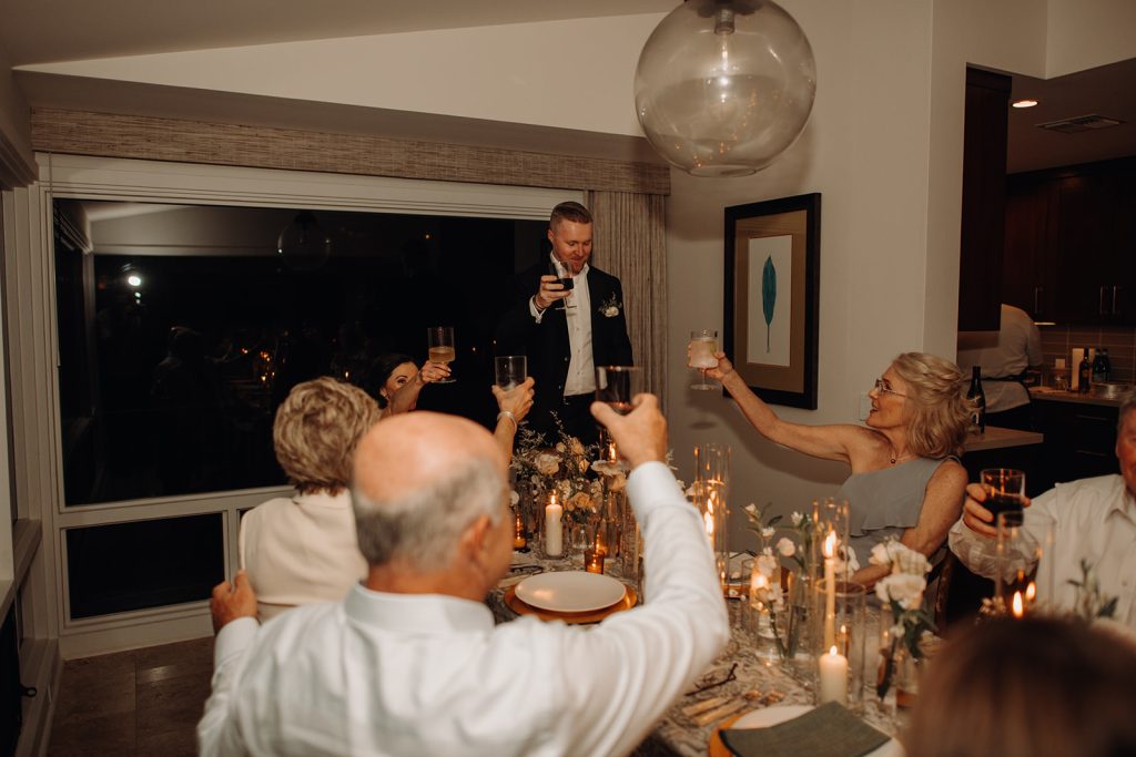 bride and groom have a cheers with their family during their wedding reception.