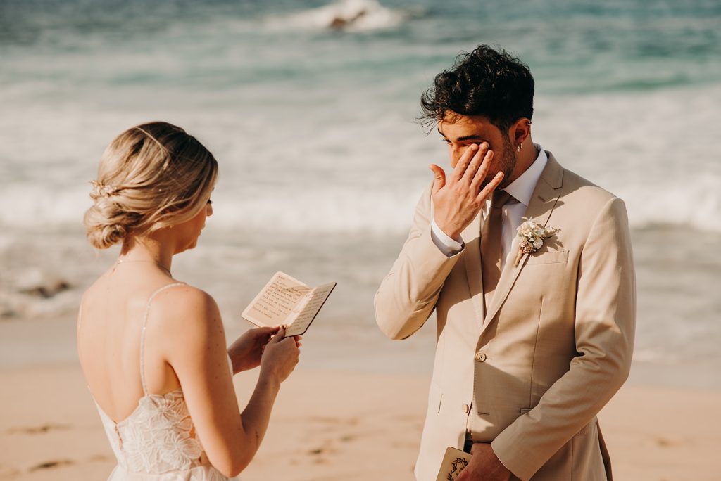 Bride and groom read emotional vows to each other on the beach in Hawaii