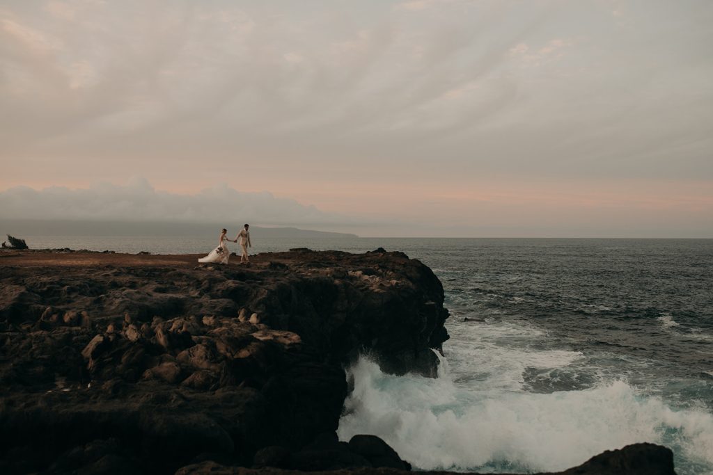 Maui elopement at sunset as couple walks on Dragon's Teeth