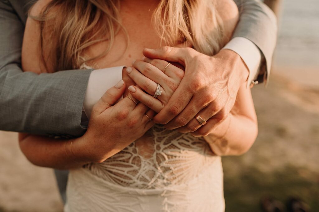 detail photo of couples hands intertwined on the beach