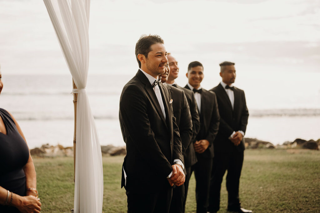 groom watching his bride walk down the aisle